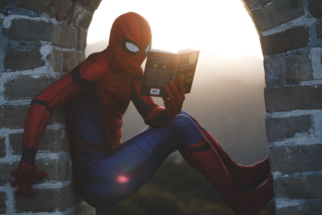 Spider man looking for champion in a book. 